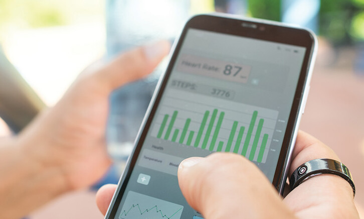 person with wearable ring checks app on phone