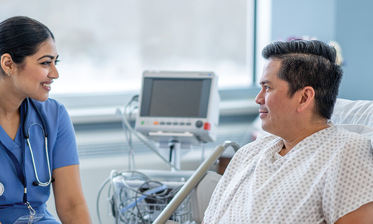 nurse talks with patient in hospital room