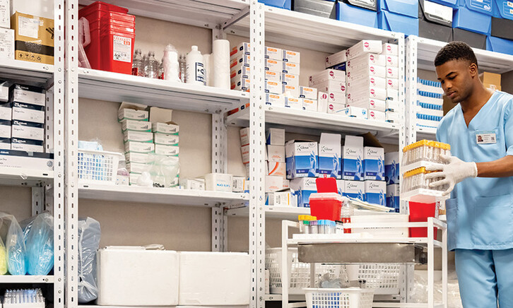 man grabs supplies in pharmacy supply room