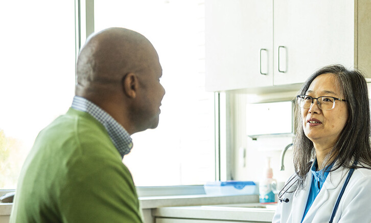 doctor talks with patient in exam room