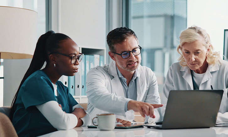 clinicians look at data on laptop