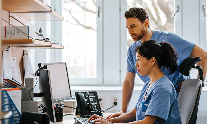 clinicians looking at computer monitor in office