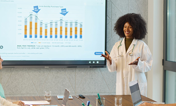doctor gives presentation in front of chart