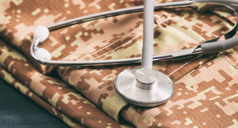 Military medical concept with stethoscope and American military digital pattern uniform, folden on wooden background
