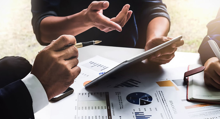 Business people using pen,tablet,notebook are planning a marketing plan to improve the quality of their sales in the future.