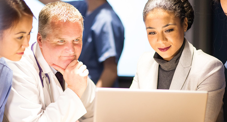 healthcare and IT leaders collaborate over laptop