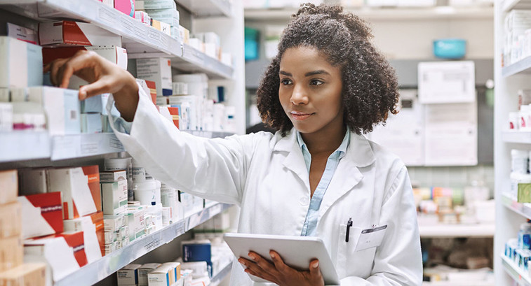 Pharmacy technician uses a tablet to fulfill a prescription order