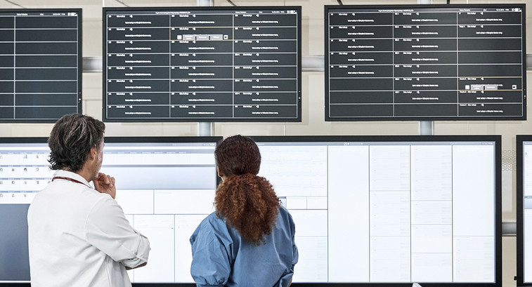 Doctors discussing over screens in control room