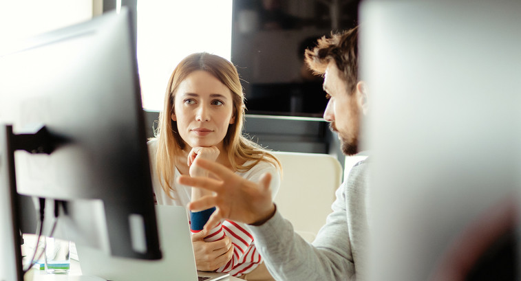 IT staff talk in front of monitor