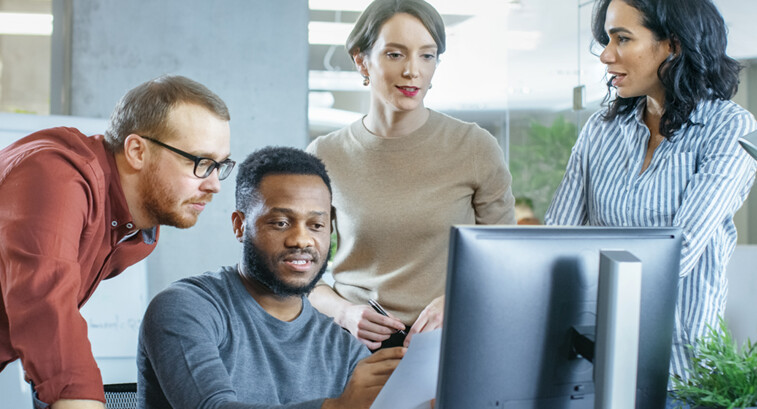 IT team discuss problem around computer