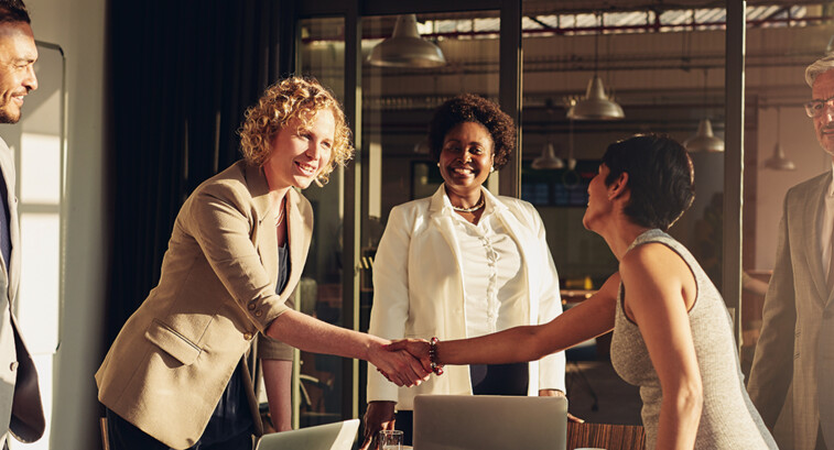 business leaders shake hands in conference room