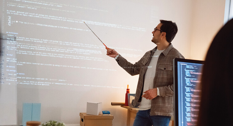 man teaches coding class using projector