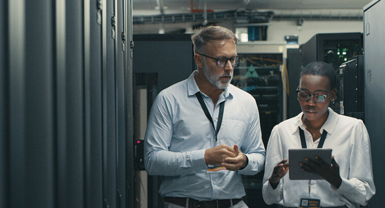 IT professionals look at tablet in data center room
