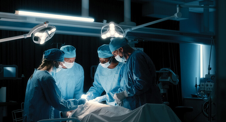 doctors perform surgery in a dark room