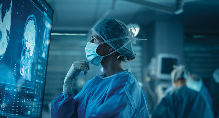 Surgeon looks at brain on a display in the OR