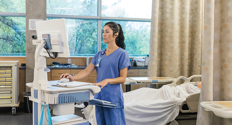 nurse on laptop in patient room