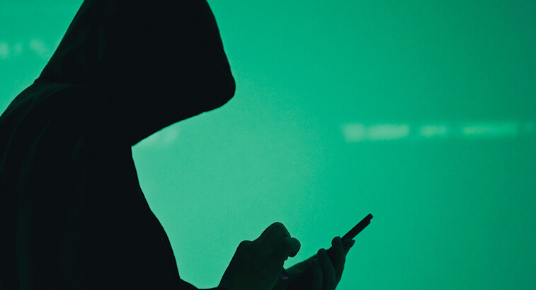 silhouette of hooded figure on phone