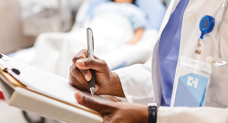 doctor uses paper charting in front of patient