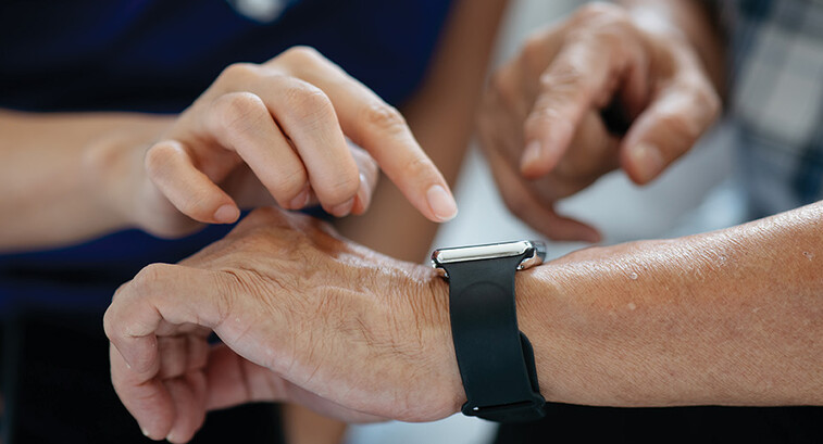 nurse helps man with wearable device