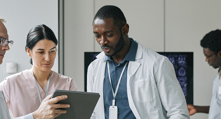 team looks at data on tablet and monitor