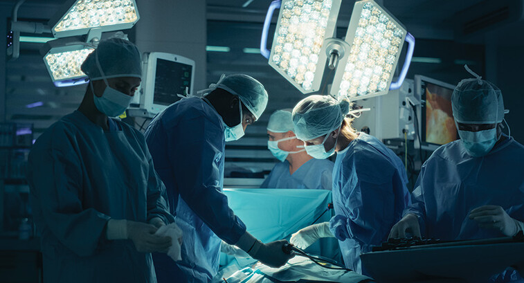 medical team performs surgery in dark room
