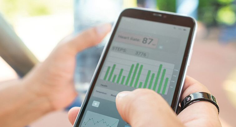person with wearable ring checks app on phone