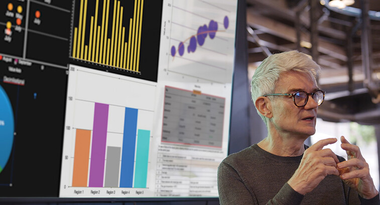 man gives presentation in front of screen with charts