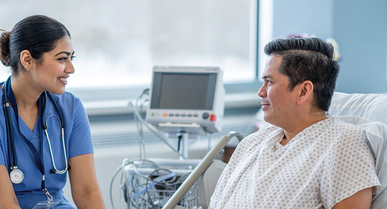 nurse talks with patient in hospital room