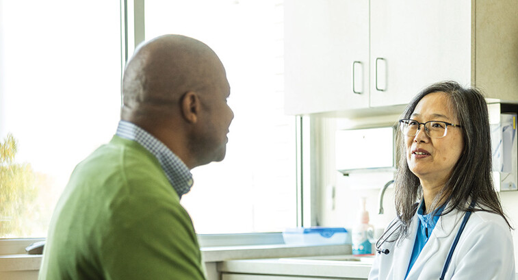doctor talks with patient in exam room