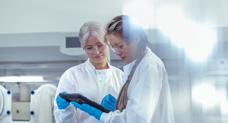 researchers discuss data on tablet in lab