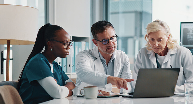 clinicians look at data on laptop