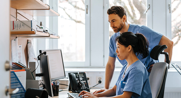 clinicians looking at computer monitor in office
