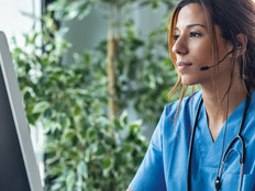 nurse monitors patients on computer - telesitting concept
