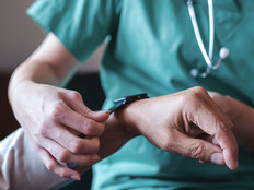 Nurse fitting patient with monitoring technology