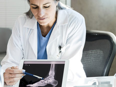 Doctor using tablet with patient 