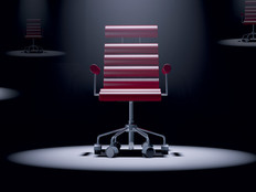 red office chair spotlit in a dark room