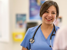 clinician talks to patient next to spine anatomy figure