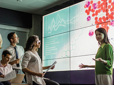 group of scientists look at medical information on a large screen