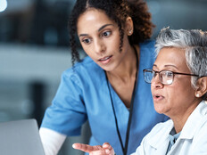 two clinicians looking at laptop