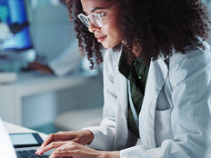 Doctor on laptop in state-of-the-art lab
