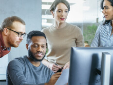 IT team discuss problem around computer