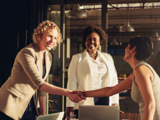 business leaders shake hands in conference room