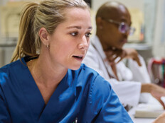 nurses talk in front of desktop computer