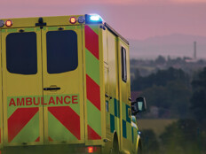 ambulance driving down country road at sunset