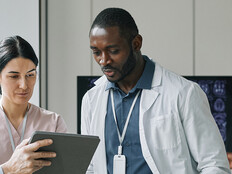team looks at data on tablet and monitor