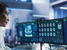 healthcare researcher looks at images and data on monitors