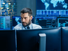 man surrounded by monitors with security data