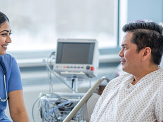 nurse talks with patient in hospital room