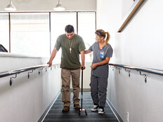 nurse helps veteran walk for rehab