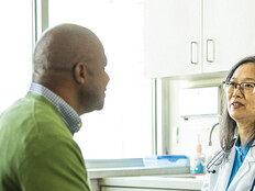 doctor talks with patient in exam room